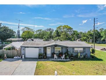Charming single-story home with a well-manicured lawn and covered front porch seating area at 5004 Suwannee Dr, New Port Richey, FL 34652