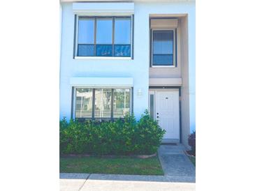 Charming two-story home featuring manicured shrubs, neutral paint, and well-lit entryway at 1849 Abrico Dr # K9, Lutz, FL 33558