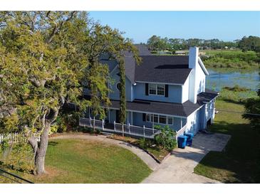 Charming two-story home with a welcoming front porch and a well-manicured lawn at 219 Galaxy Ave, Spring Hill, FL 34606
