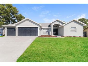 Charming single Gathering home with a manicured lawn and a spacious three car garage at 2203 Malaga Ave, Spring Hill, FL 34609