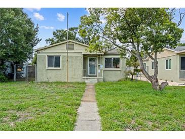 Charming one-story home with a green lawn and mature tree in a residential neighborhood at 2435 37Th N Ave, St Petersburg, FL 33713