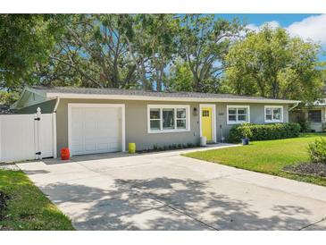 Charming single-story home with a well-manicured lawn and bright yellow front door at 3302 W Beaumont St, Tampa, FL 33611