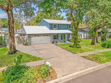 Charming two-story home with a two-car garage and a lush green lawn at 9410 Alanbrooke St, Temple Terrace, FL 33637