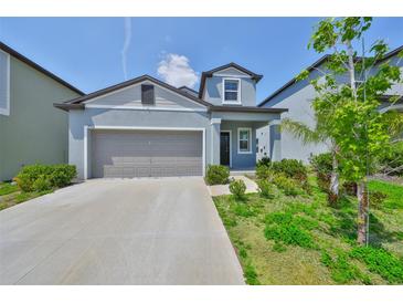 Charming light blue two-story home with a two-car garage and well-maintained landscaping at 9914 Calypso Orchid Ct, Riverview, FL 33578