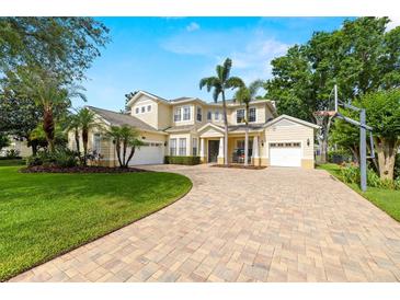 Beautiful two-story home showcasing lush landscaping, brick paver driveway, and a welcoming three-car garage at 2207 Climbing Ivy Dr, Tampa, FL 33618