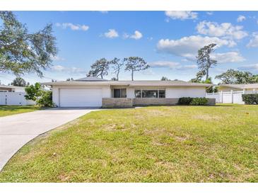 Well-kept single-story home with a manicured lawn and a convenient attached garage at 1714 Cypress Ave, Belleair, FL 33756