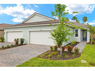 Charming single-story home with a three-car garage and a well-manicured lawn at 20423 Symphony Pl, Venice, FL 34293