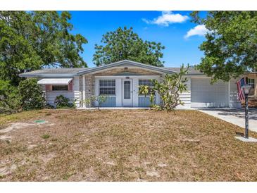 Charming single-story home with an attached garage, tidy landscaping, and a well-manicured lawn at 4017 Moog Rd, Holiday, FL 34691