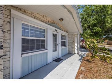 Inviting front porch features a stone facade, windows, and a well-lit entrance, offering a charming welcome at 4017 Moog Rd, Holiday, FL 34691
