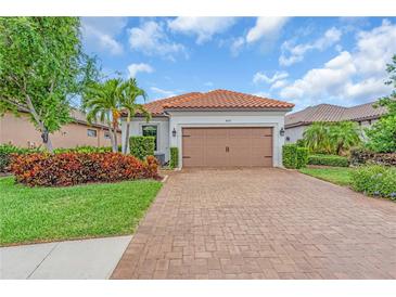 Charming single-story home featuring a tile roof, brick driveway, and manicured landscaping at 4610 Alexandria Ct, Palmetto, FL 34221