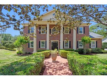 Stunning brick home with stately columns, manicured lawn, and charming front walkway at 5017 Muir Way, Lithia, FL 33547