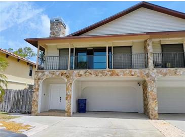 Two-story home with stone accents, upper balcony, and a three-car garage at 7085 Sunset S Dr # A, St Petersburg, FL 33707
