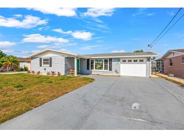 Charming single-story home with gray exterior, well-maintained lawn, and a long driveway at 12700 5Th Isle, Hudson, FL 34667