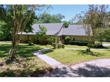 Charming single-story home with a well-manicured front yard and a welcoming pathway at 16224 Iola Woods Trl, Dade City, FL 33523