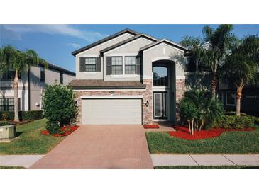 Charming two-story home featuring a brick-accented facade, well-manicured lawn, and a spacious two-car garage at 19314 Long Lake Ranch Blvd, Lutz, FL 33558