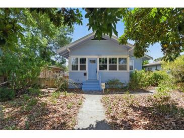 Charming bungalow with light blue exterior, front porch, and mature trees in an established neighborhood at 2710 8Th N Ave, St Petersburg, FL 33713