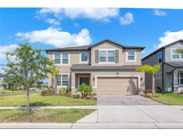Charming two-story home with a two-car garage and beautifully landscaped front yard, perfect for suburban living at 3113 Marine Grass Dr, Wimauma, FL 33598