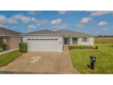 Charming home featuring a well-manicured lawn, two-car garage, and inviting landscaping at 11311 Corey Pavin Ln, San Antonio, FL 33576
