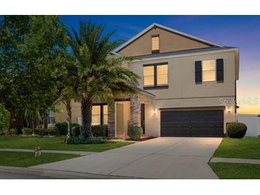Two-story home featuring stone accents, well-manicured lawn, mature landscaping and an attached two car garage at 11760 Winterset Cove Dr, Riverview, FL 33579
