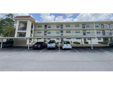 Exterior view of condo complex showing covered parking at 1375 Doolittle Ln # 101, Dunedin, FL 34698