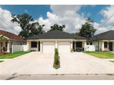 Charming duplex featuring a well-manicured lawn and matching attached two-car garages at 4106 N Thatcher, Tampa, FL 33614
