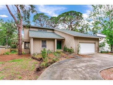 Charming home featuring a well-maintained lawn, lush landscaping, and a welcoming front entrance at 4802 W Dryad St, Tampa, FL 33629