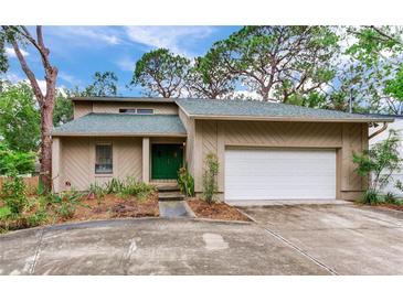 Charming home with attached garage and well-maintained lawn, lush landscaping, and a welcoming front entrance at 4802 W Dryad St, Tampa, FL 33629