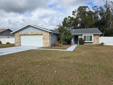 Charming single-story home with stone accents, a two-car garage, and a well-maintained front yard at 23015 Mayfair Rd, Land O Lakes, FL 34639
