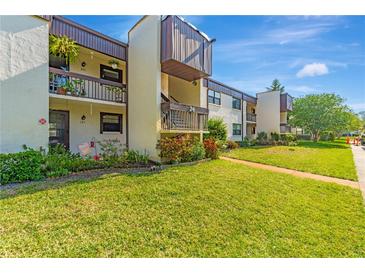 Well-maintained condominium complex with lush landscaping, inviting walkways, and private balconies at 2400 Winding Creek Blvd # 24-102, Clearwater, FL 33761