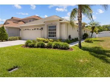 Beautiful single-story home with lush landscaping, well-manicured lawn, and attached two-car garage at 25830 Crippen Dr, Land O Lakes, FL 34639