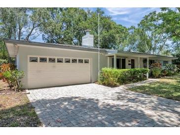 Charming single story home with a 2-car garage and a well-manicured lawn at 1242 Nelson St, Dunedin, FL 34698