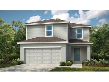 Two-story home featuring a two-car garage, gray siding, and a cozy front porch surrounded by lush landscaping at 13273 Tropical Breeze Way, Hudson, FL 34669