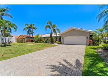 Charming single-story home with a spacious driveway, well-manicured lawn, and lush tropical landscaping at 1941 Kentucky Ne Ave, St Petersburg, FL 33703
