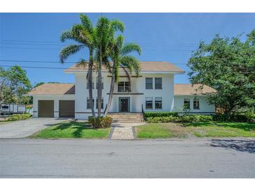 A two-story home with a white exterior, a brown roof and two palm trees in the front yard at 2114 S Venus St, Tampa, FL 33629