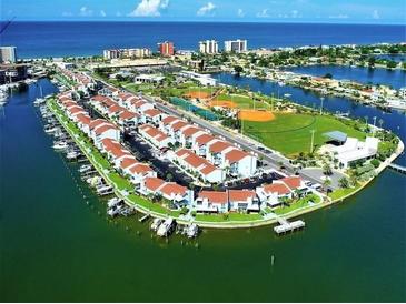 Stunning aerial view of waterfront condos, a marina, and recreational amenities at 250 Medallion Blvd # H, Madeira Beach, FL 33708