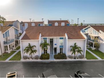 An attractive exterior shot of a two-story townhome with well-maintained landscaping and easy access to parking at 250 Medallion Blvd # H, Madeira Beach, FL 33708