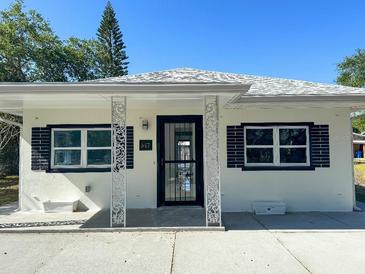 Charming renovated single-story home with crisp white paint, decorative pillars, and freshly sealed driveway at 547 16Th S Ave, St Petersburg, FL 33701