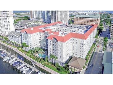Luxury condo building with a red roof, waterfront access, boat docks, and a refreshing pool surrounded by lush landscaping at 700 S Harbour Island Blvd # 342, Tampa, FL 33602