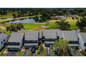 An aerial view of a townhome community situated on a golf course with water views at 9050 Park Blvd # 5, Seminole, FL 33777