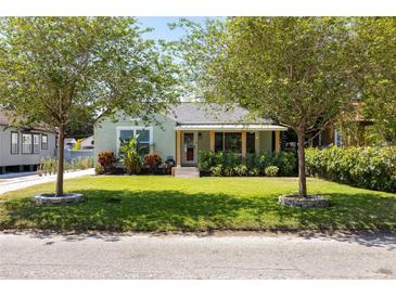 Charming bungalow with a well-manicured lawn and inviting front porch, framed by mature trees at 1008 W Braddock St, Tampa, FL 33603