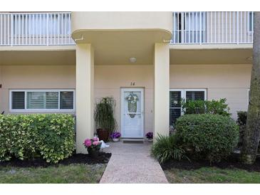 Charming condo featuring a covered front entryway with decorative plants and well-maintained landscaping at 2021 Shangrila Dr # 14, Clearwater, FL 33763
