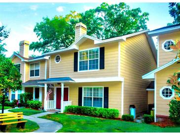 Inviting two-story townhouse featuring a well-maintained lawn and charming exterior details at 3086 Pointer Dr, Palm Harbor, FL 34683