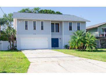 Two-story home with a large driveway, garage, and beautifully maintained landscaping at 320 Crosswinds Dr, Palm Harbor, FL 34683
