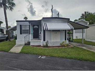 Charming single story home featuring an awning and a small landscaped garden area at 4851 W Gandy Blvd # B3L12, Tampa, FL 33611
