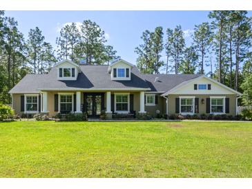 Charming home featuring a well-manicured lawn, classic architectural details, and inviting curb appeal at 5458 Zamia Dr, Brooksville, FL 34604