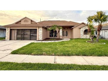 Charming single-story home with well-manicured lawn, stone accents, and an attached two-car garage at 8127 Tarsier Ave, New Port Richey, FL 34653