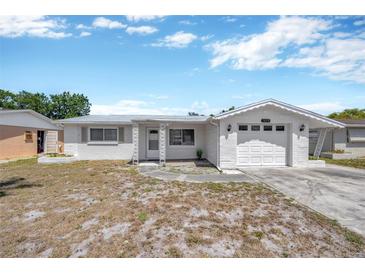 Charming single-story home featuring a classic design and a well-maintained front yard in a quiet neighborhood at 1408 Dartmouth Dr, Holiday, FL 34691