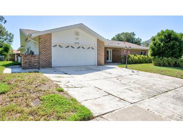 Charming single-story home featuring a spacious two-car garage and traditional brick accents at 2675 Firestone Dr, Clearwater, FL 33761