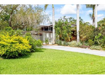 Inviting home featuring lush landscaping and a long driveway leading to a mid-century modern home at 3130 Walnut Ne St, St Petersburg, FL 33704