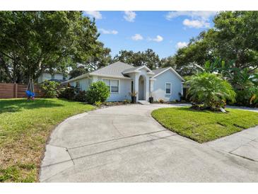 Charming single-story home featuring a well-manicured lawn, mature trees, and a welcoming entryway with a curved driveway at 3417 W Alline Ave, Tampa, FL 33611